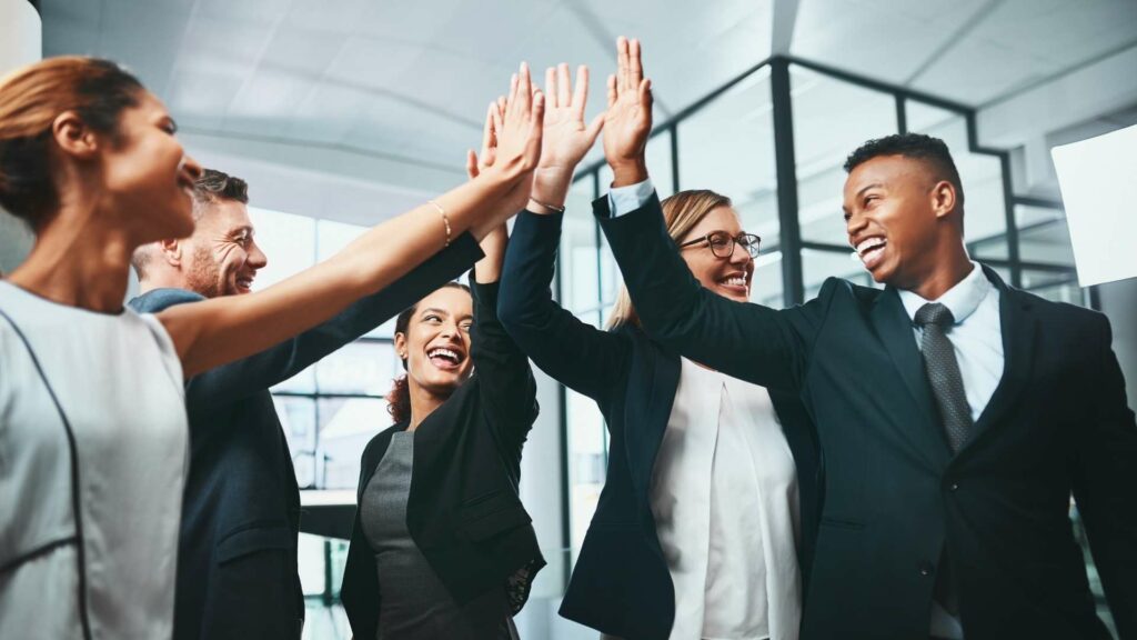 Messeauftritt planen: Standpersonal klatscht sich ab